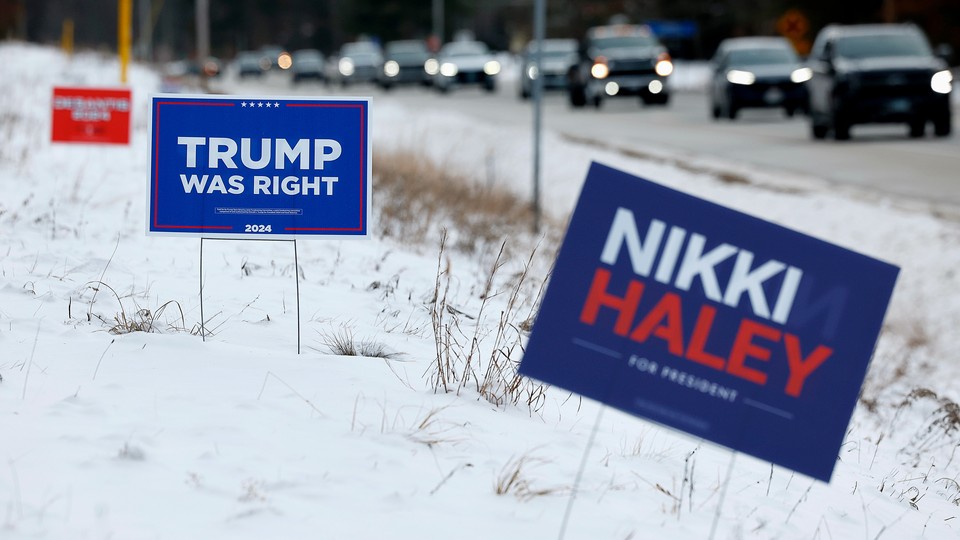 Campaign signs for Donald Trump and Nikki Haley stand in the snow in Loudon, New Hampshire