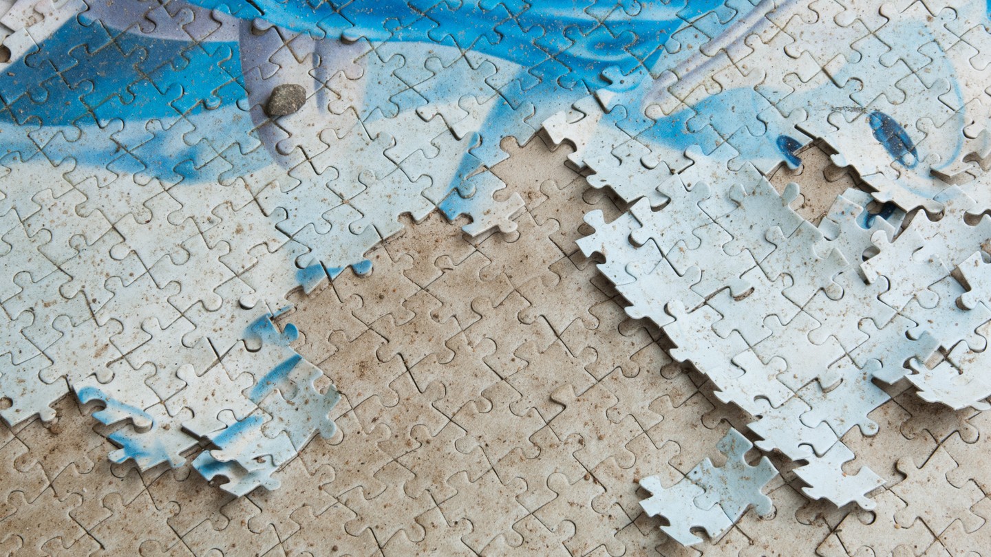 A blue and white puzzle on a beige surface that also has a puzzle imprint