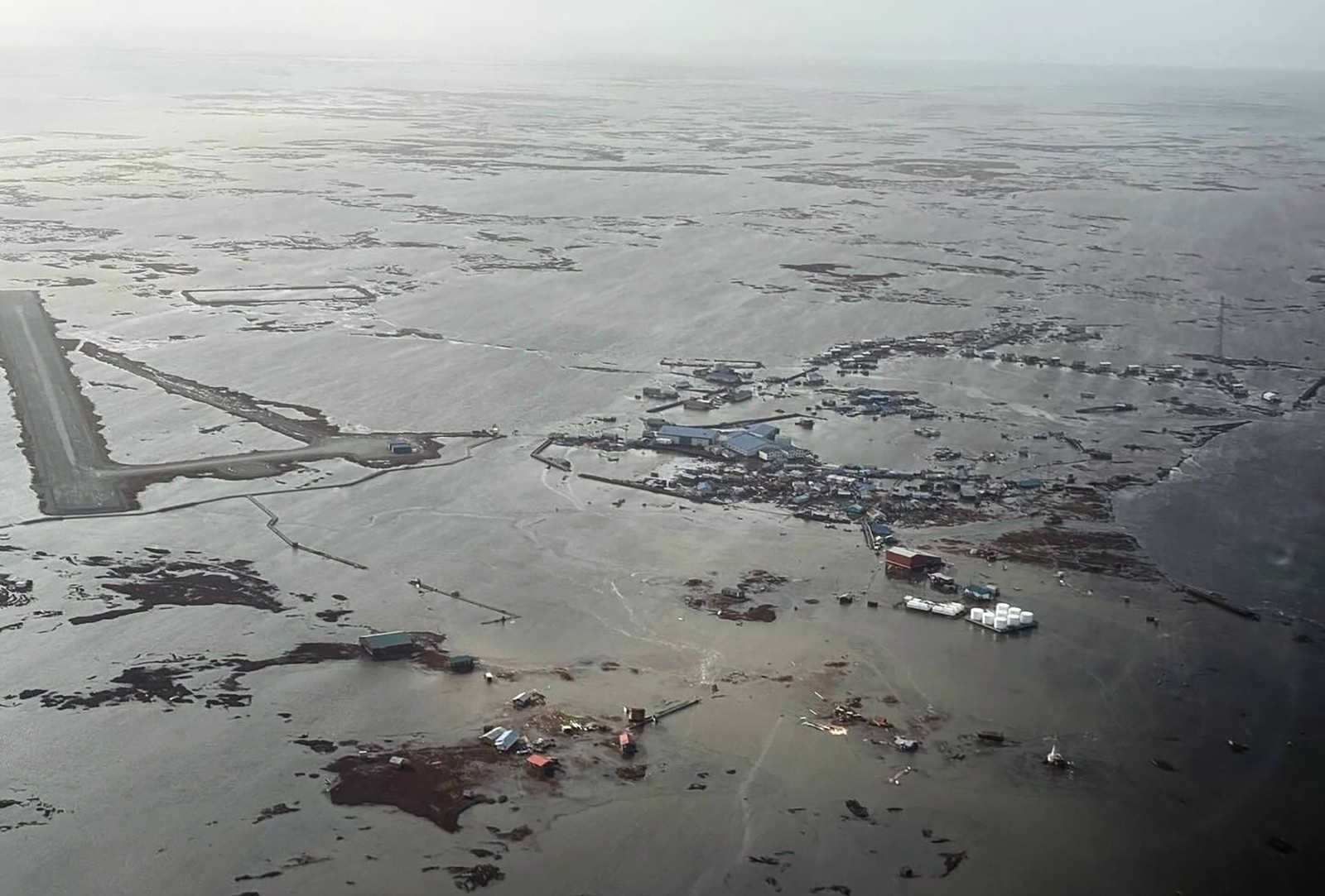 An aerial view of a flooded plain and village in Alaska, following a devastating storm.