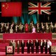 Chinese and British leaders stand beneath the flags of China and the United Kingdom.