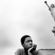 A boy sits near the Statue of Liberty.