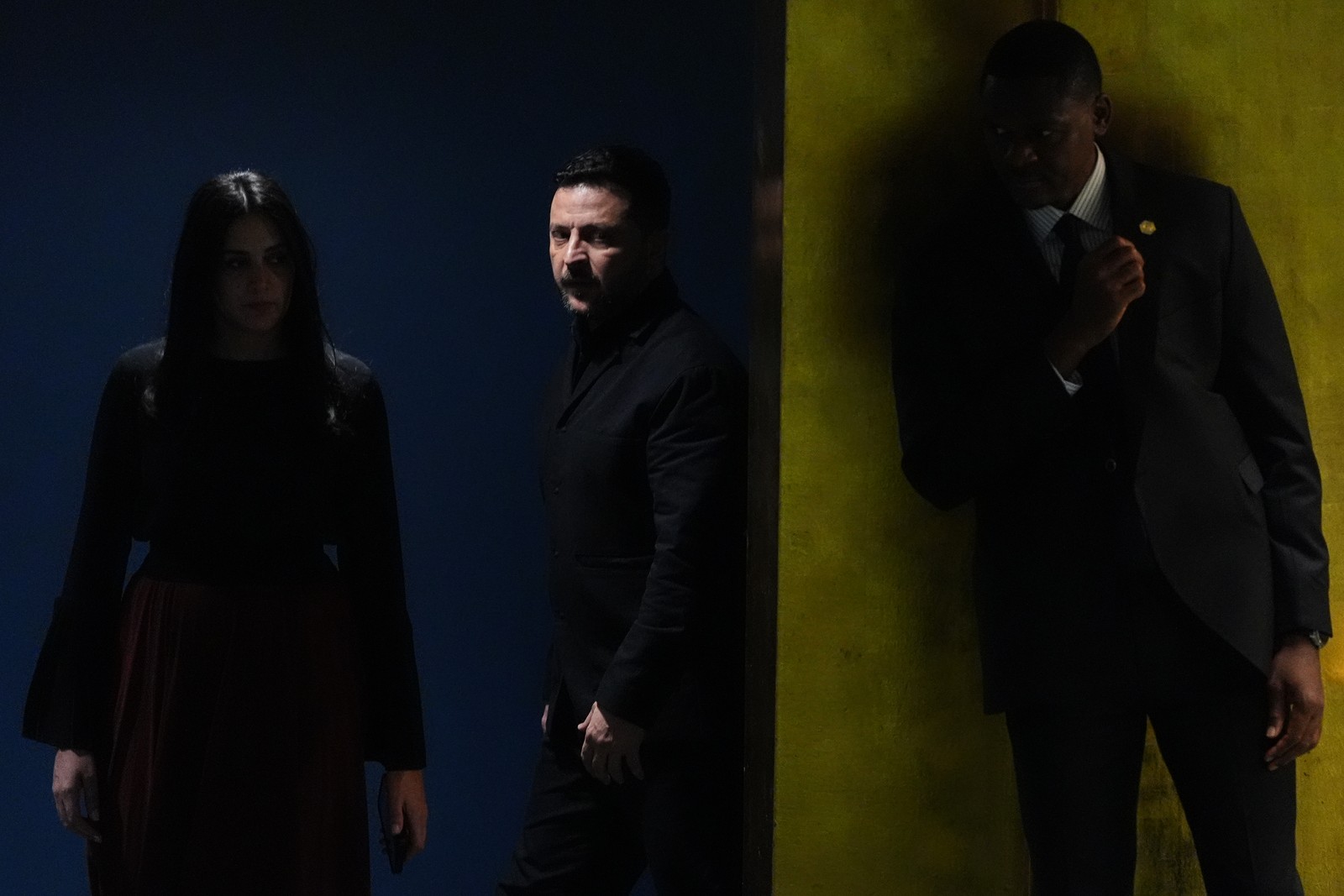 Ukraine's President Volodymyr Zelenskyy walks through a dark passage before giving a speech.