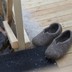 A Russian man eases himself into icy water while his slippers wait on a deck.
