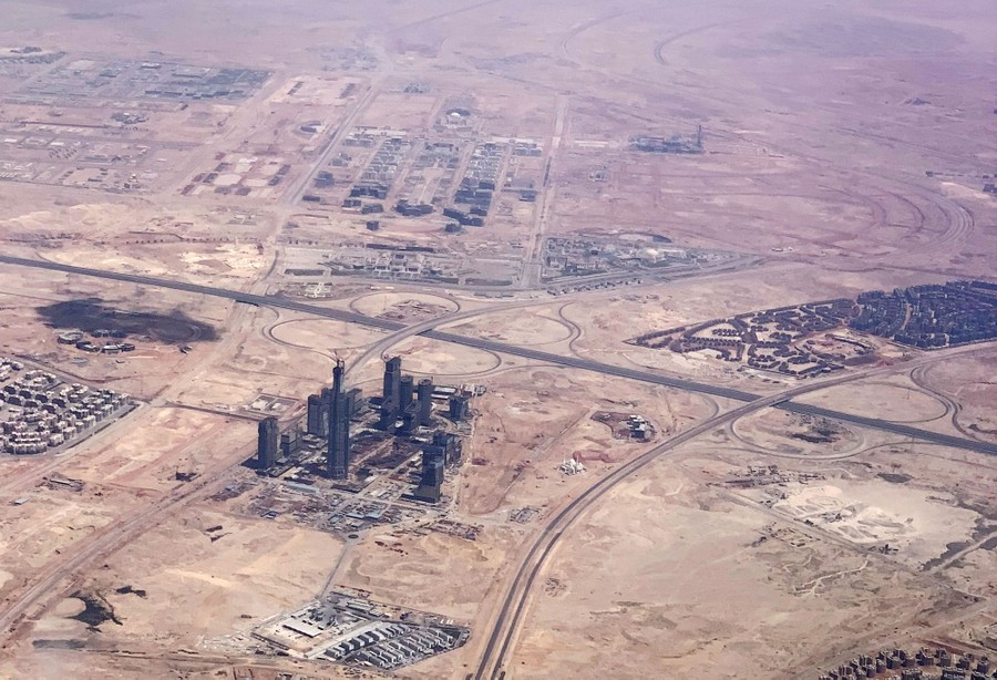 An aerial view of several large construction sites in a desert