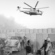A black-and-white photo of U.S. soldiers in Afghanistan with a helicopter overhead