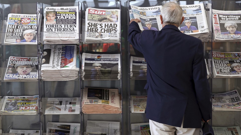 A man picks up a newspaper reporting on the outcome of the U.K.’s general election in London on June 10, 2017. 