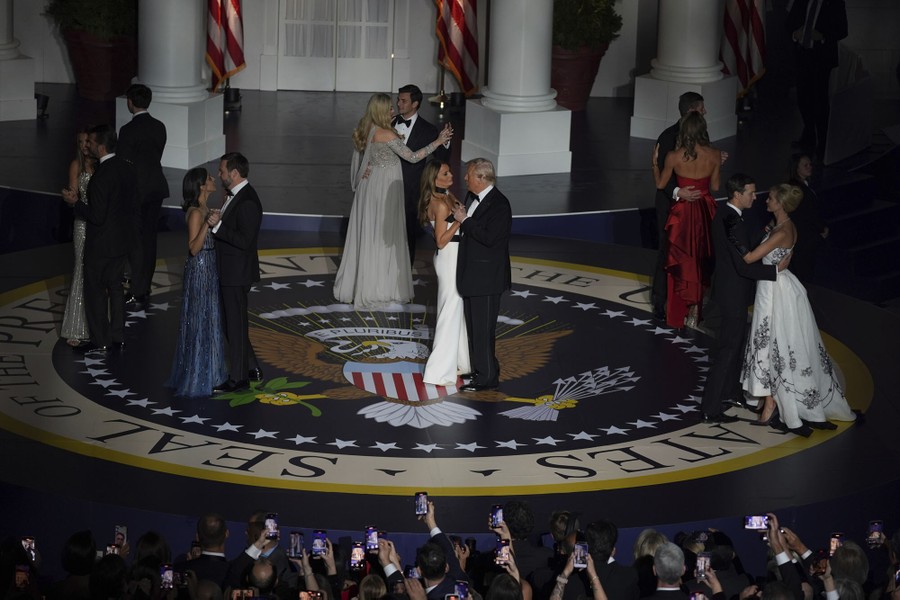President Donald Trump, first lady Melania Trump, and others dance on a circular stage covered with the seal of the president of the United States.
