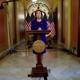 Nancy Pelosi stands in front of American flags and a lectern at the Capitol.