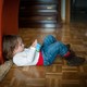A child on the floor looking at a smartphone