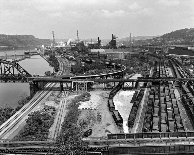 black-and-white photo of rail yard and river scene 