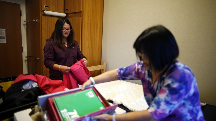 A student and her mom are unpacking in a dorm room.