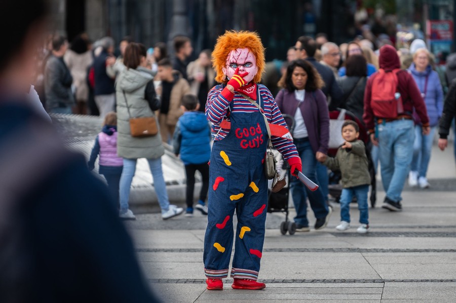 A man dressed as the movie character Chucky is seen in a city square.