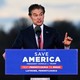 Dr. Mehmet Oz speaks at a lectern that reads "Save America"