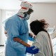 Medical staff member Marvin Alexander (L) gives a physical exercise to a patient in the COVID-19 intensive care unit (ICU) on Christmas Eve at the United Memorial Medical Center on December 24, 2020 in Houston, Texas. According to reports, Texas has reached over 1,650,000 cases, including over 26,600 deaths.