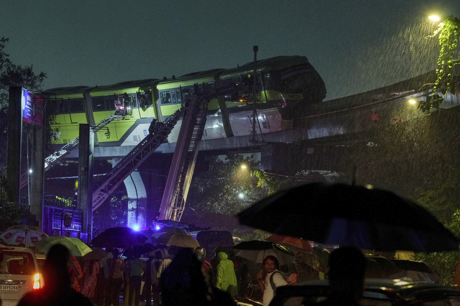 Rescue crews use extended ladders to reach people stranded on stuck monorail cars.