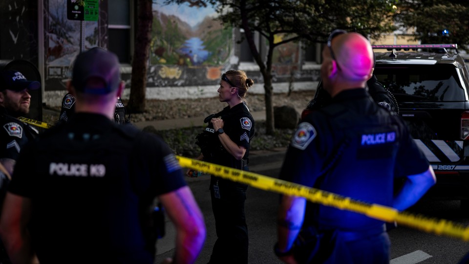 A color photograph of police standing in a street, attending the scene of a terror attack in Boulder, Colorado.