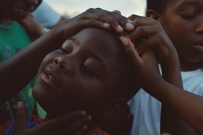 Three young boys tenderly holding one another