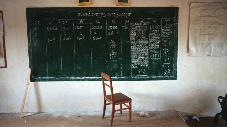 A chair sits at the bottom of a blackboard with election tallies written on it.