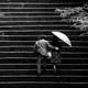 A black-and-white photo of a couple walking up some steps