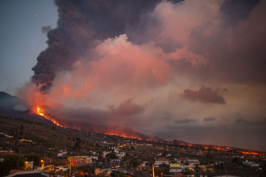 A view of a lava flow setting numerous fires along its path.