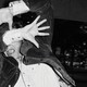 A man covers his face with his hands while he's photographed.