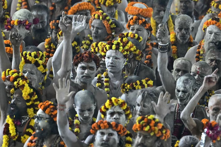 A group of holy men, covered in white ash, wearing floral garlands