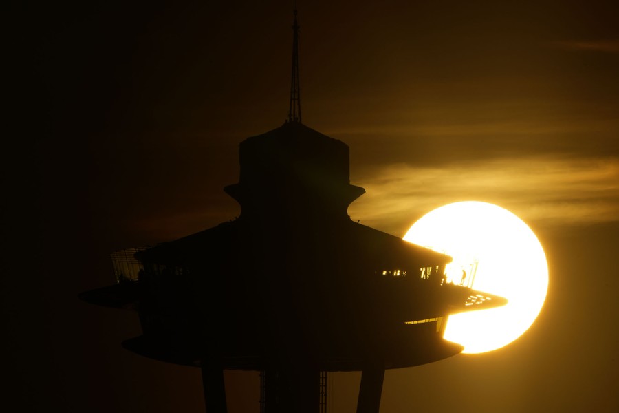 The sun sets behind the Space Needle in Seattle.