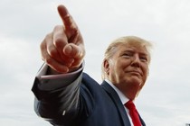 President Donald Trump points at a cheering crowd.