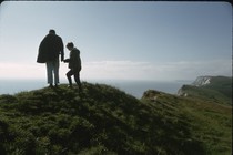 A man and a child standing atop a mountain