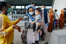 Afghan refugees line up to board a bus upon arrival at Dulles International Airport in Dulles, Virginia.