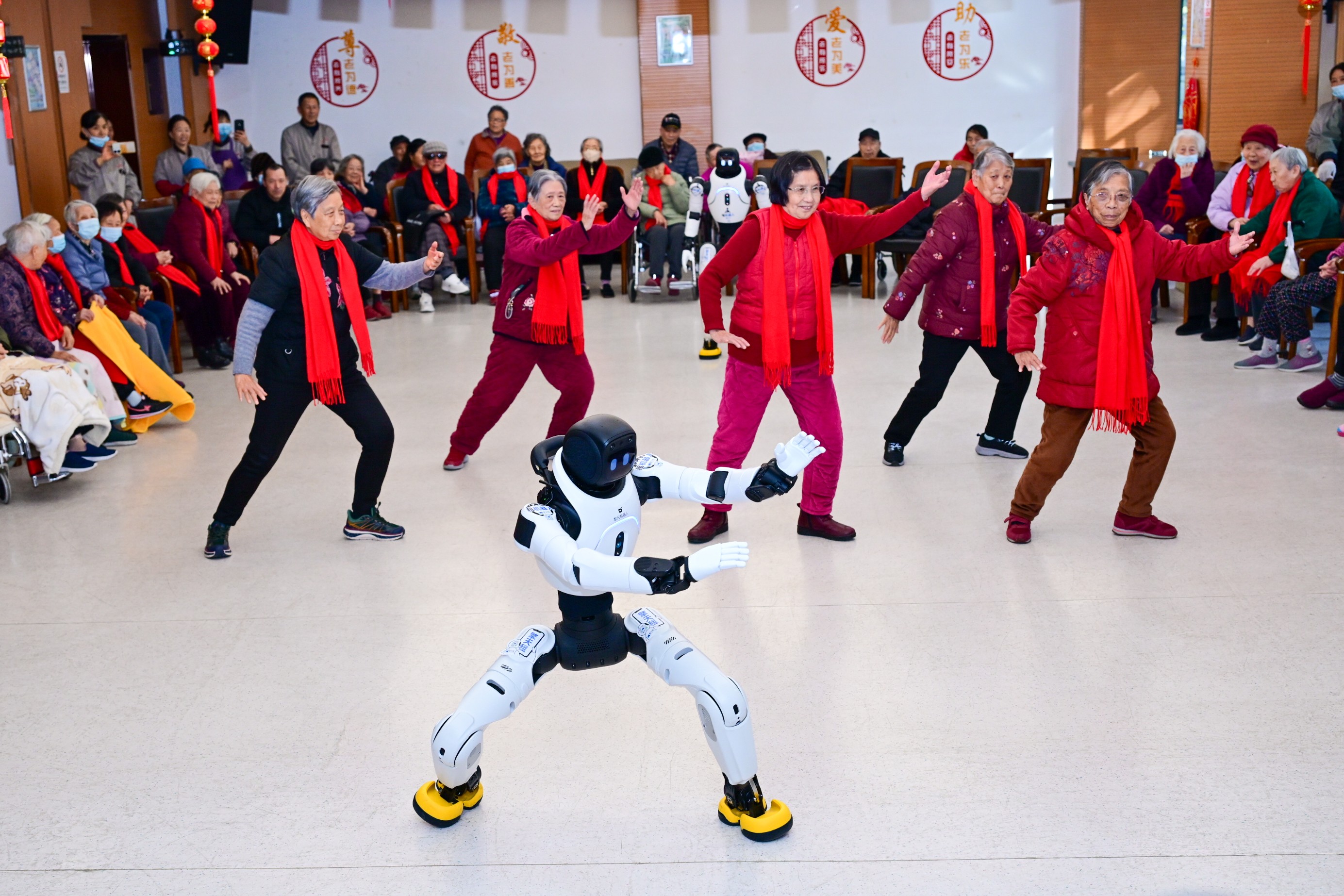 A group of older women perform beside a humanoid robot.