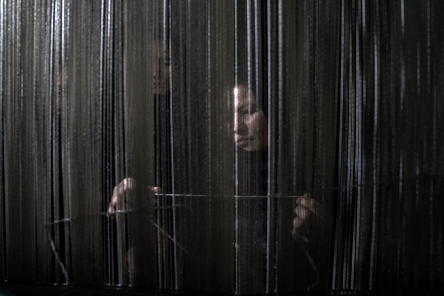 An Afghan woman weaves a carpet.