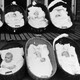 Ten babies, all but one sleeping, rest in baskets on a porch outside a maternity ward.