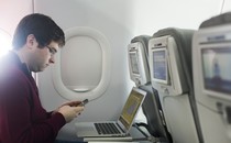 A man using his laptop on the plane
