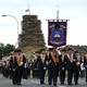 Participants in an Orange Order parade march past a bonfire pyre in Portadown, Northern Ireland.
