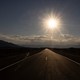 Photo of a low sun above a long road