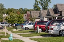 A photo from 2016 of various kind of cars in people's driveways on a suburban street