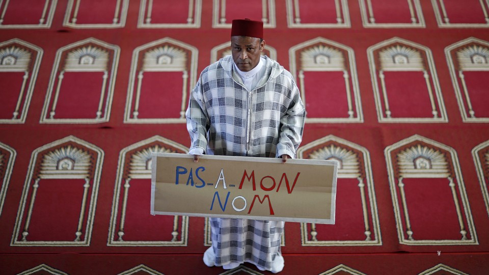 Khaloar Abdarahim holds a placard reading "Not in my name" as he poses inside the Arrahma Mosque in Nantes, France, in 2014.