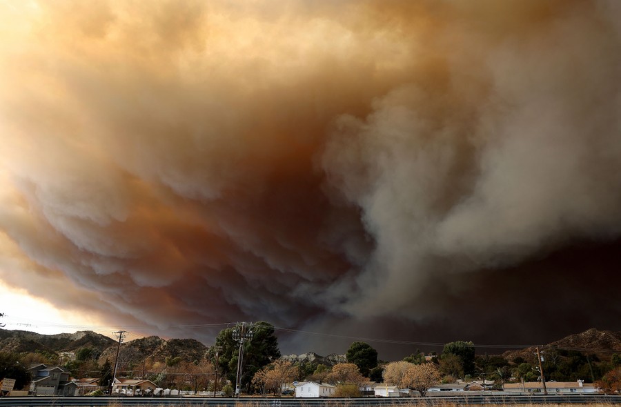 The sky is filled with dark smoke from a nearby wildfire.