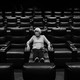 A woman sits alone in an empty movie theater