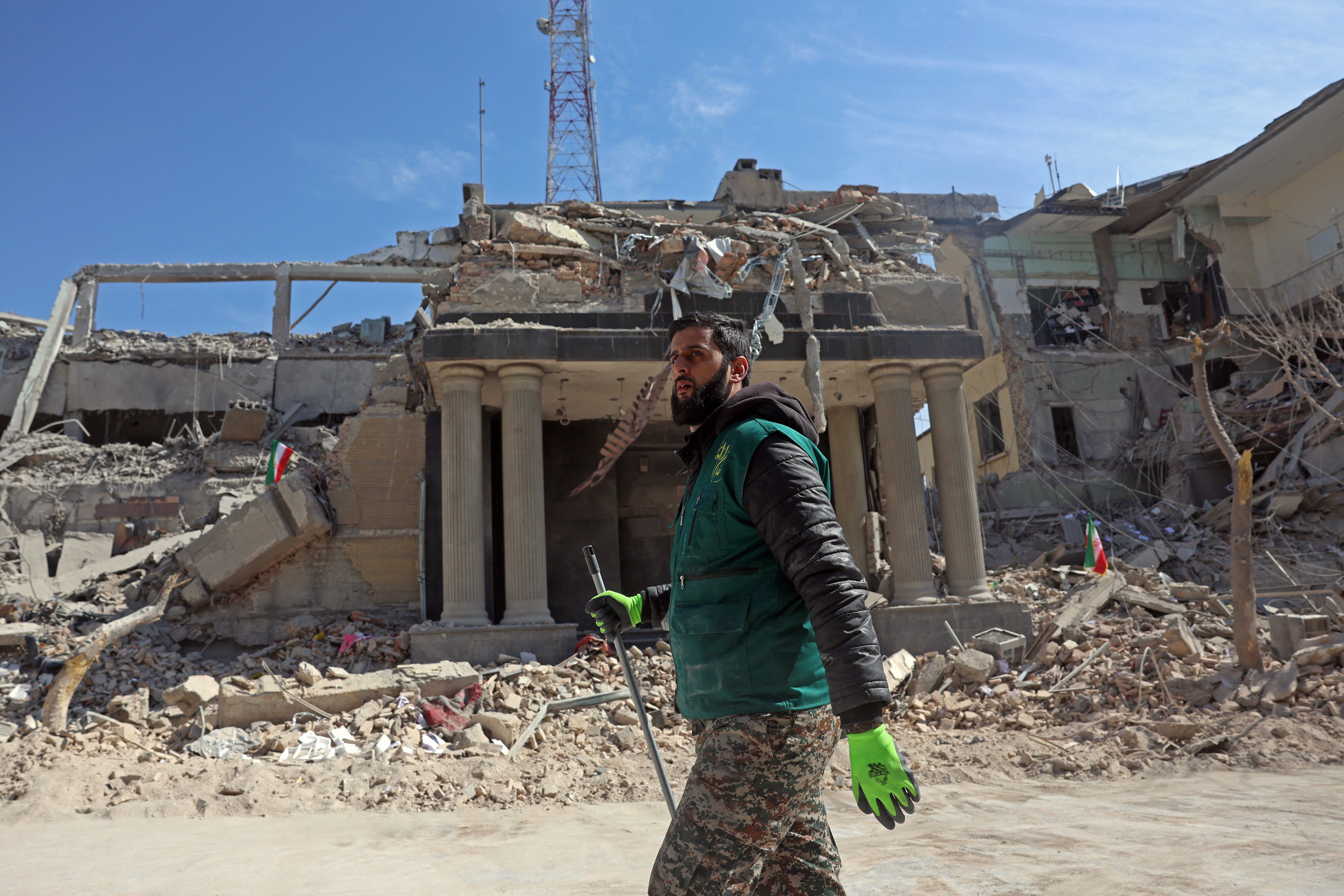 A man walks past destroyed buildings following airstrikes in Tehran.