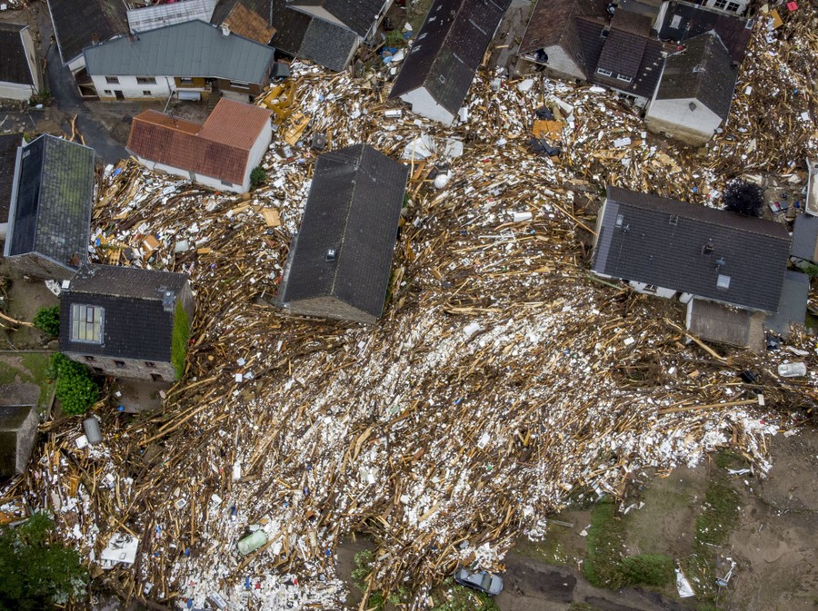 Flood debris surrounds houses, seen from above.