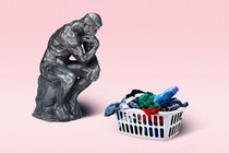 Auguste Rodin's sculpture 'The Thinker' next to a basket of laundry