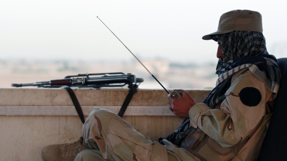 A private security organization contractor listens to a radio during his duty at guard tower in Camp Nathan Smith in Kandahar City May 7, 2010.
