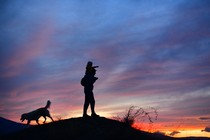 A father and son walk at dusk