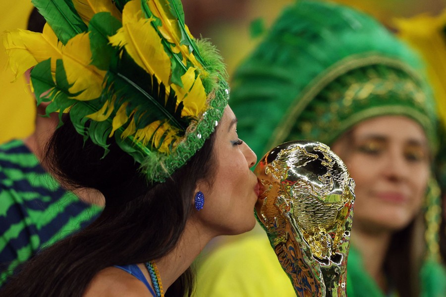 A Brazil supporter kisses a replica of the world cup trophy.
