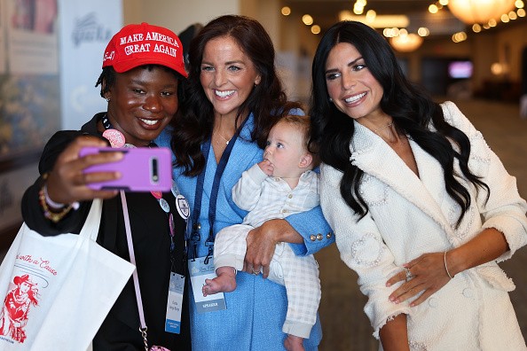 a color photograph of Chaida Bango Bango, Kate Johnson, and Alex Clark taking a photo together