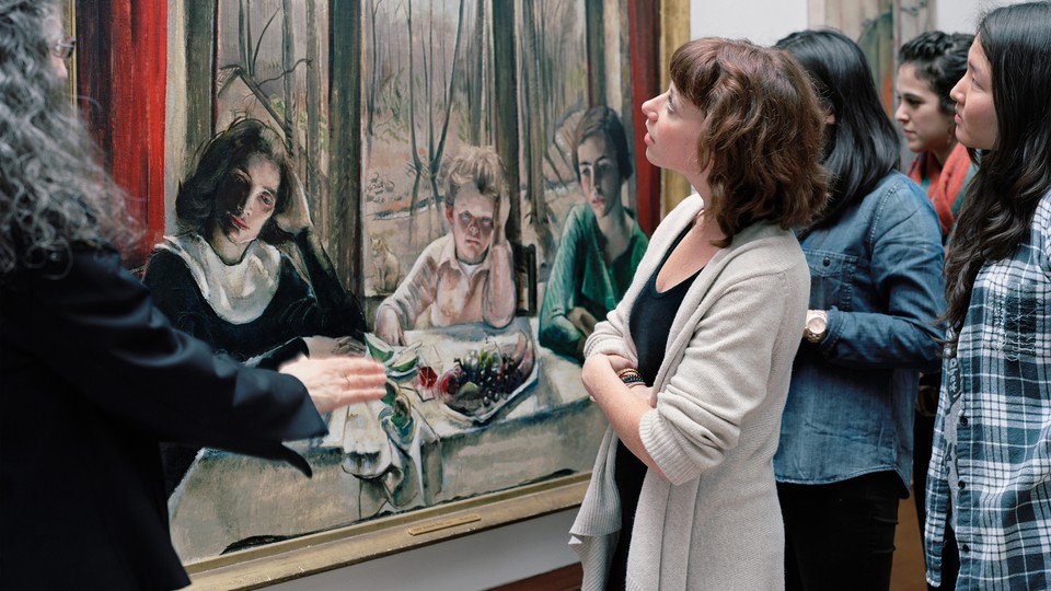 A group of bystanders look at a painting.