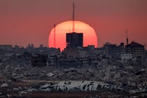 A photo of the sun setting behind destroyed buildings in Palestinian territory.