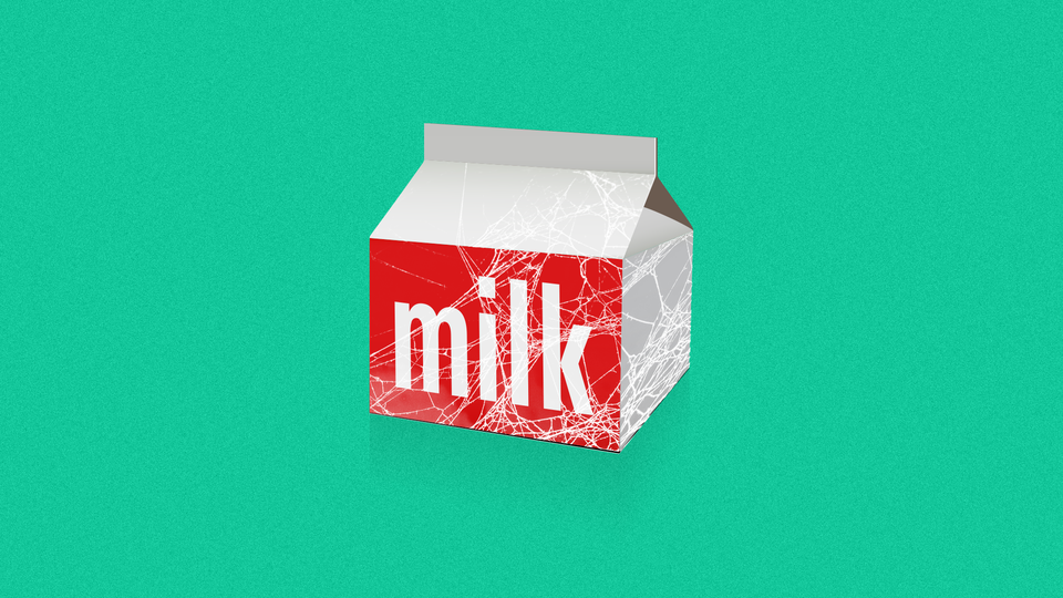 A carton of milk covered in spiderwebs
